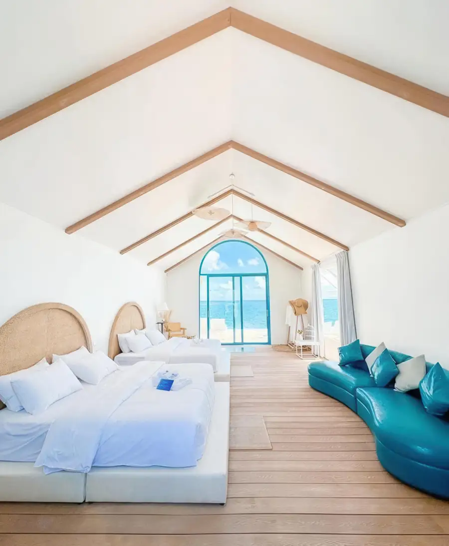 Two beds with blue sofa in Family Suite Royal Resort Semporna